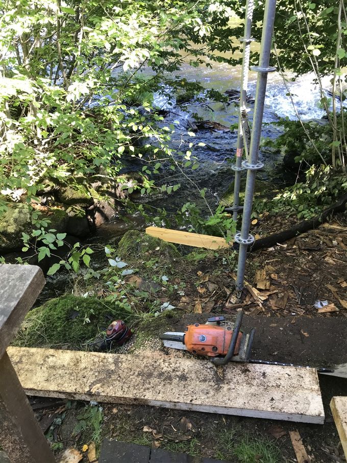 Rensning efter rännan försvårades av buskage mellan byggnad och ån.